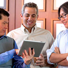 3 people looking at a tablet